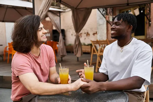 Una coppia amorevole gode di un appuntamento gioioso, sorseggiando bevande e tenendosi per mano in un accogliente caffè. — Foto stock