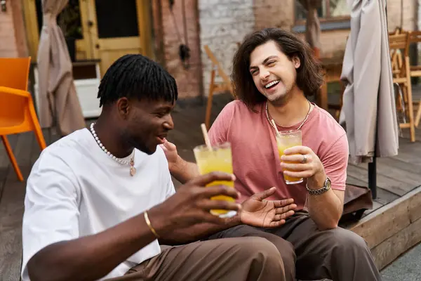 Um casal gay amoroso desfruta de seu tempo em um café acolhedor, rindo e brindando suas bebidas juntos. — Fotografia de Stock