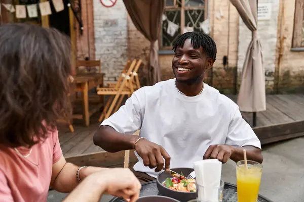 Dois indivíduos bonitos desfrutar de uma conversa sincera e uma deliciosa refeição em um café acolhedor. — Fotografia de Stock