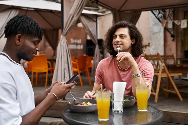 Two loving men share a delightful lunch, filled with laughter and connection at a cozy cafe. — Stock Photo