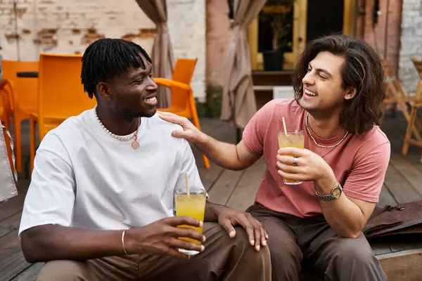 Hermosa pareja comparte un momento de alegría con bebidas en la mano, sentado de cerca en un vibrante café. - foto de stock