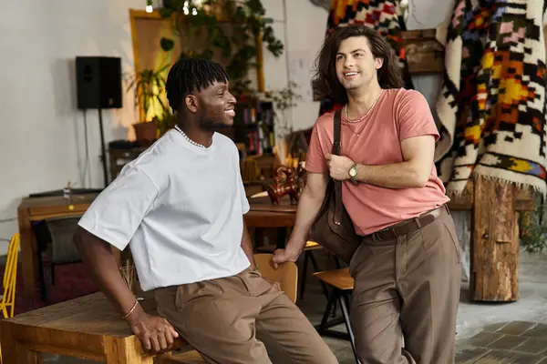 Dos hombres guapos comparten sonrisas y risas mientras pasan tiempo de calidad juntos en un encantador café. - foto de stock