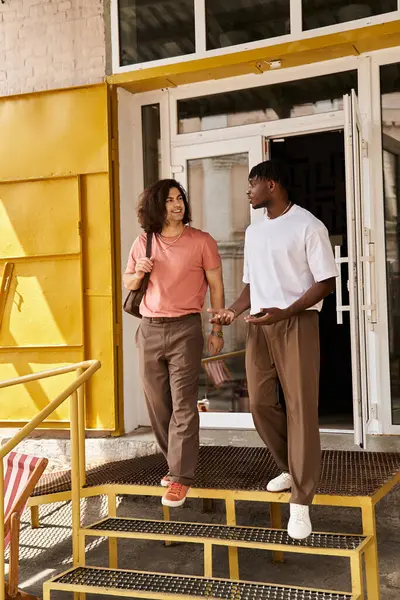 A loving couple walks hand in hand, sharing smiles outside a welcoming cafe with sunny vibes. — Stock Photo