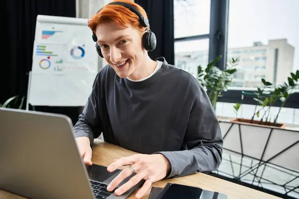 Focused young man with striking red hair engages in his tasks at a contemporary office space. — Stock Photo