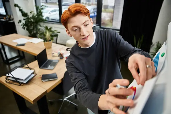 A young man with red hair collaborates in an inspiring office using a whiteboard. — Stock Photo