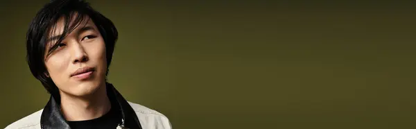 Young man with a trendy outfit showcases his style in a well-lit studio space, banner — Stock Photo