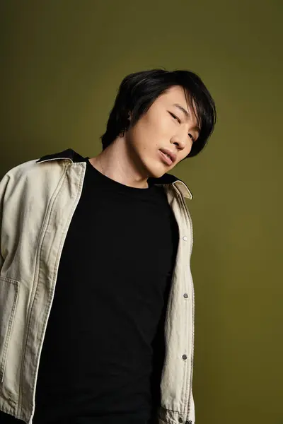 Asian young man in a stylish outfit showcases his fashion sense in a studio setting. — Stock Photo