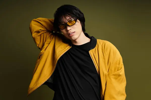 A young asian man showcases his fashion sense while posing in a contemporary studio setting. — Stock Photo