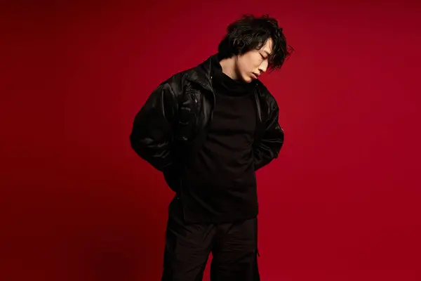 A handsome young asian man is in a studio with red background. — Stock Photo