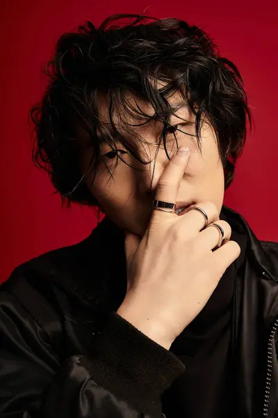 Stylish young Asian man posing in studio with red background. — Stock Photo