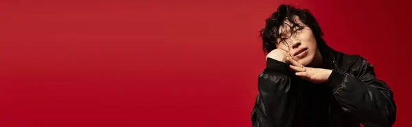 Stylish and pensive young asian man posing in a red studio, banner — Stock Photo