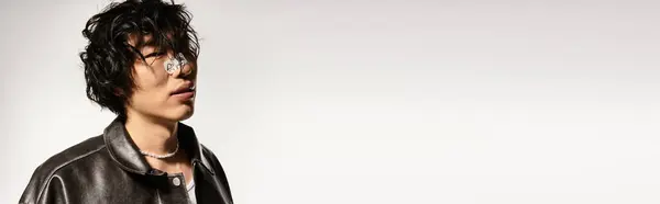 Young Asian man, modern style, leather jacket, pearls, studio pose, banner — Stock Photo