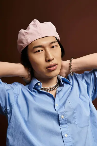 Un jeune homme asiatique met en valeur son sens de la mode tout en posant dans un studio moderne. — Photo de stock