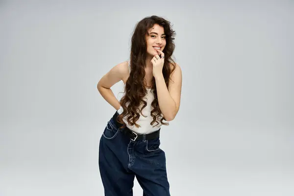 Charmante Frau posiert in stilvollem Outfit, strahlt Selbstbewusstsein und verspielte Anziehungskraft in einem trendigen Studio aus. — Stockfoto