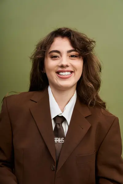 Woman poses in a chic brown suit, exuding confidence and charm amidst a vibrant backdrop. — Stock Photo
