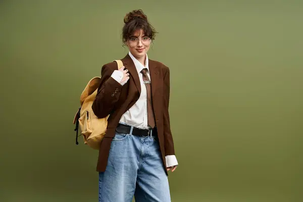 Donna alla moda brilla in giacca oversize, jeans casual, e uno zaino in un ambiente elegante. — Foto stock