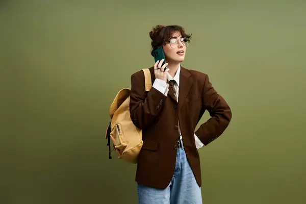 A stylish young woman confidently poses with a backpack, exuding modern chic in urban surroundings. — Stock Photo