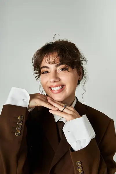 A young, pretty woman showcases her stylish attire, radiating confidence and charm while smiling. — Stock Photo