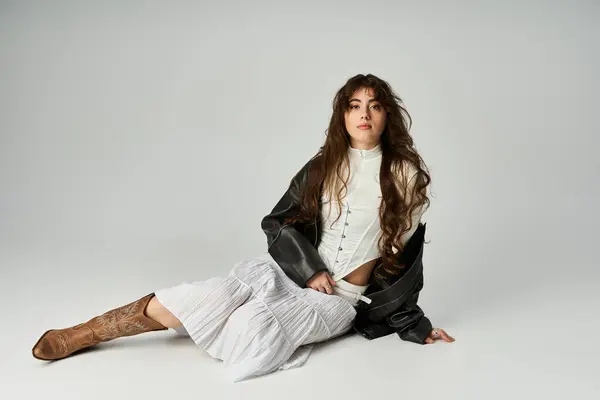 A young woman sits gracefully, flaunting her stylish attire while exuding confidence and charm. — Stock Photo