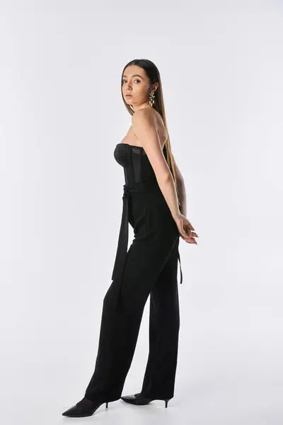 Chic young woman poses confidently against a white backdrop, radiating elegance. — Stock Photo