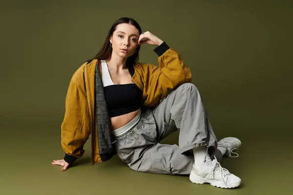Fashionable woman strikes a confident pose in trendy attire, playing with contemporary styles. — Stock Photo