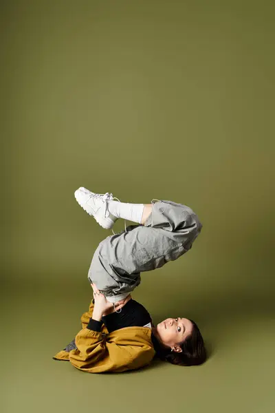 A young woman shows off her unique style while playfully balancing on her back. — Stock Photo
