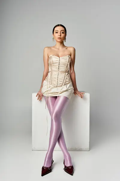 Trendy young woman poses confidently against a minimalist backdrop. — Stock Photo