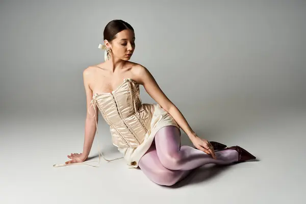 Una joven mujer bonita posa elegantemente con un atuendo elegante, rodeada de un fondo de estudio minimalista. - foto de stock