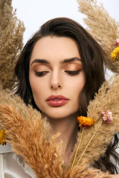 A young woman stands gracefully among vibrant flowers, embodying spring charm and beauty. — Stock Photo