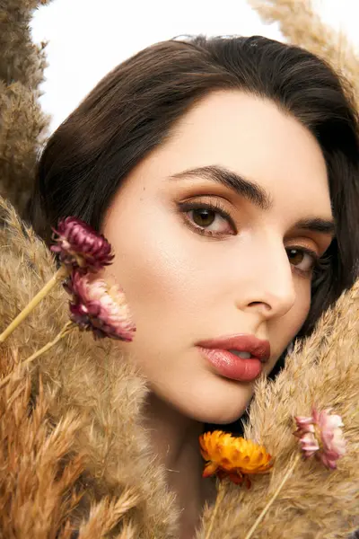 A young woman with brown hair enjoys the beauty of vibrant flowers in a spring-inspired setting. — Stock Photo