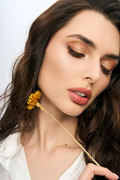 A young woman with brown hair interacts with vibrant spring flower, radiating beauty. — Stock Photo