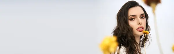 Bright spring blooms complement a young woman beauty, enhancing the fresh studio atmosphere, banner — Stock Photo