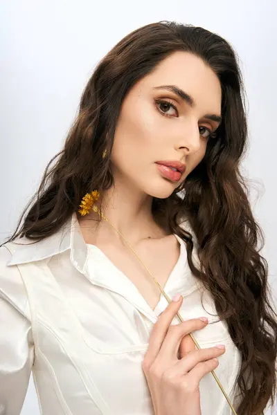 A stunning young woman with brown hair holds a flower, embodying the spirit of spring. — Stock Photo