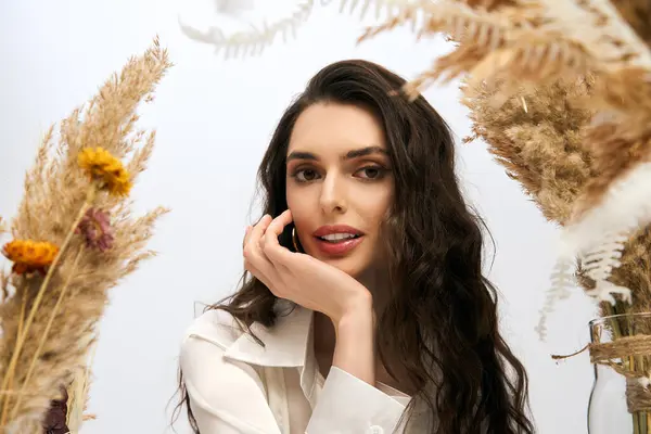 A young woman with brown hair enjoys the beauty of spring surrounded by vibrant flowers. — Stock Photo