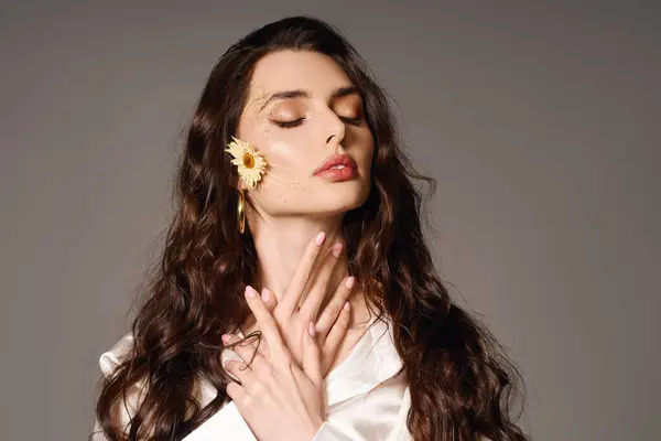 A young woman with brown hair poses gracefully, adorned with spring flowers, radiating beauty. — Stock Photo
