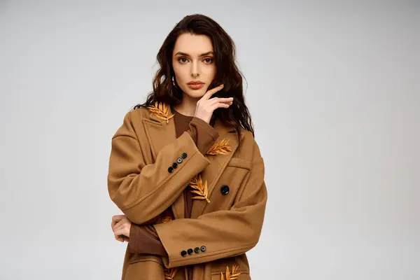 A beautiful young woman with long brown hair wearing a stylish coat with natural elements — Stock Photo