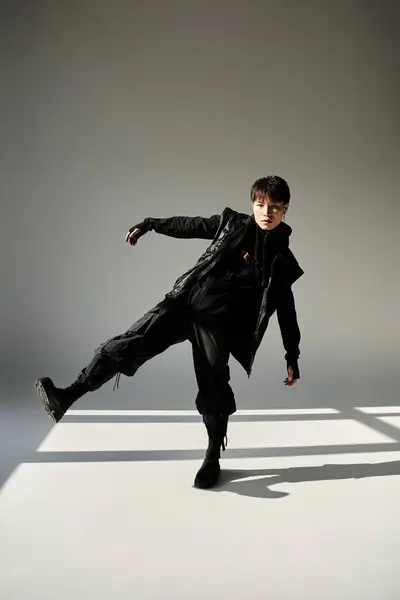 A handsome young man showcases his fashion sense while posing dramatically in a modern studio. — Stock Photo