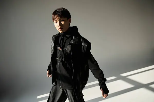 Handsome young man exudes charm while dressed in trendy black attire, basking in natural light. — Stock Photo
