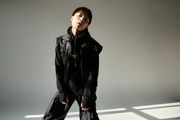 Ein stilvoller junger asiatischer Mann steht selbstbewusst da und betont sein trendiges Outfit und seinen einzigartigen Stil. — Stockfoto