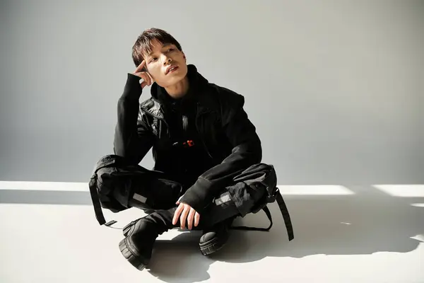 A stylish young Asian man sits comfortably on the floor, exuding a relaxed vibe. — Stock Photo