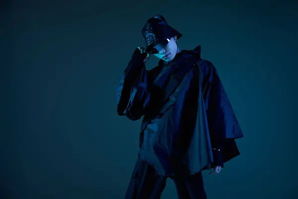 A stylish young man in a trendy oversized outfit poses with flair against a bold backdrop. — Stock Photo