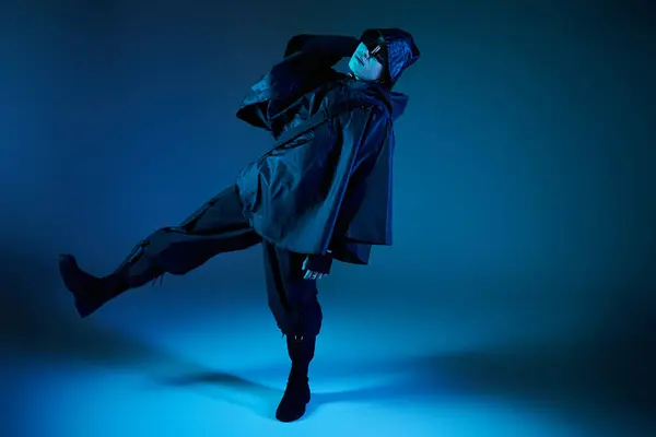 Un jeune homme pose avec confiance dans le style dans un contexte bleu frappant. — Photo de stock
