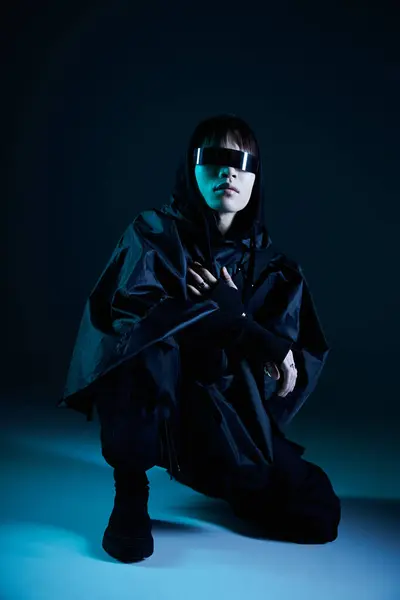 A stylish young Asian man crouches confidently, showcasing unique eyewear and a striking look. — Stock Photo
