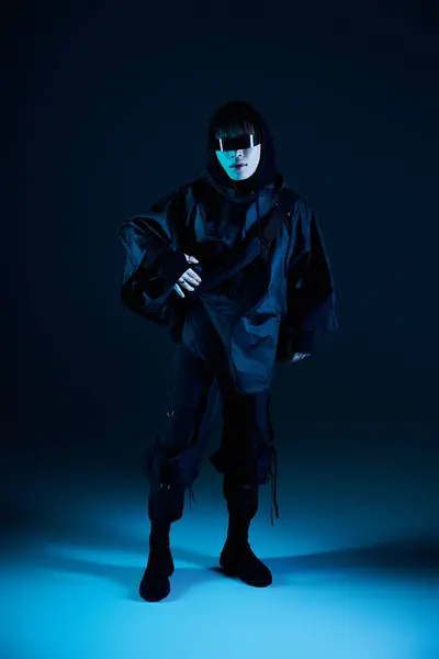 A fashionable asian man stands confidently in a sleek black ensemble showcasing his unique style. — Stock Photo