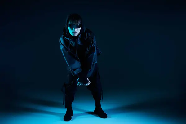 Handsome young man dressed in fashionable attire, striking an edgy pose against a dark backdrop. — Stock Photo