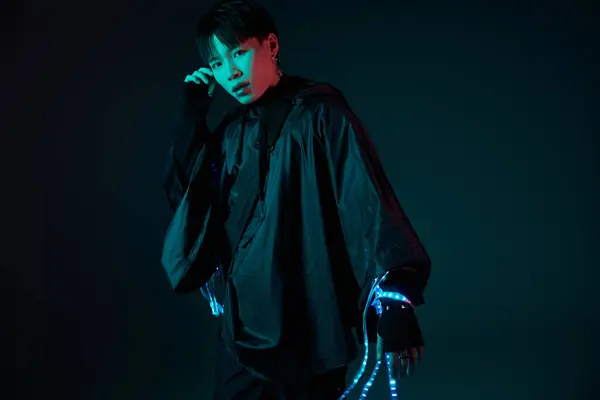 Confident young man poses in a striking outfit with bright details against a dark background. — Stock Photo