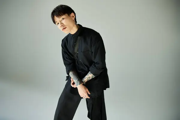 Handsome young man poses confidently in modern attire against a neutral backdrop. — Stock Photo