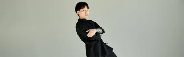 A handsome young Asian man stands confidently in a contemporary space while posing elegantly. — Stock Photo