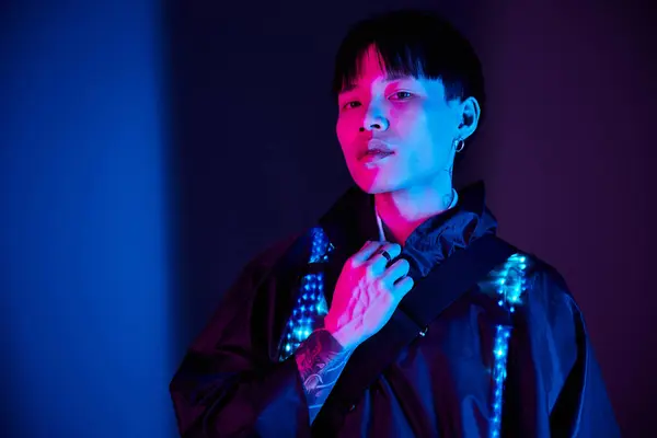 Confident young asian man stands against a colorful backdrop, showcasing his unique fashion sense. — Stock Photo