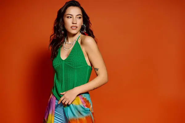 A young beautiful woman radiates summer vibes with her colorful outfit against a warm backdrop. — Stock Photo